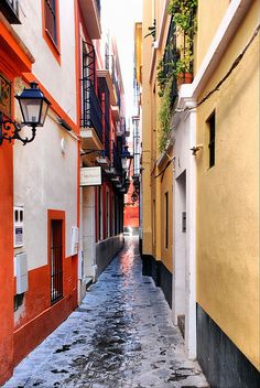 an alley way with red and yellow buildings on both sides