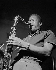 a man playing a saxophone in black and white