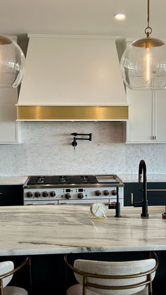 White, Black, and Gold Kitchen. The range hood is a Tapered range hood with brass apron Tapered Range Hood, Hoodsly Range Hood, Modern Vent Hood Ideas, Plaster Hood Kitchen, Kitchen Hoods Ideas, Modern Craftsman Kitchen, Modern Kitchen Hood, White Kitchen Hood, Wooden Range