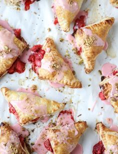 strawberry hand pies with pink icing and sprinkles on white paper