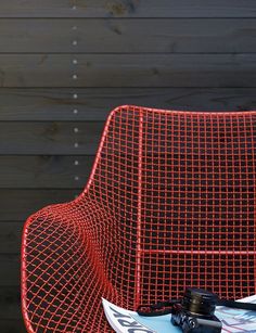 a red chair with a pair of skis on it's seat and a magazine laying on top