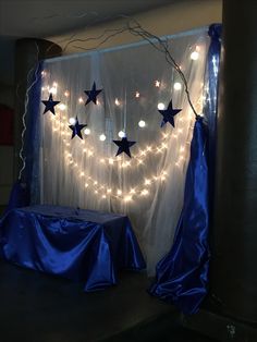 the curtain is decorated with lights and stars on it's side, along with a blue table cloth