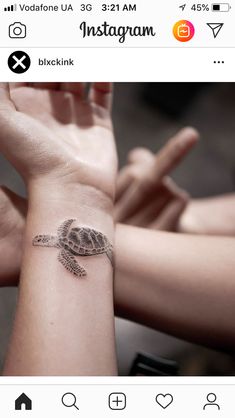 a small tattoo on the wrist of a woman's arm that has a turtle on it