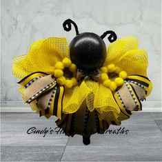 a black ball and yellow mesh wreath on top of a table