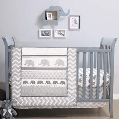 a baby crib with an elephant and chevrons on the bedding is shown