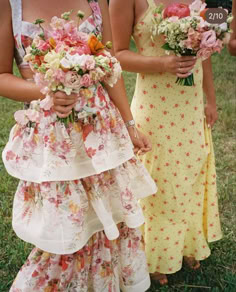 two women standing next to each other in dresses with flowers on the bottom tiers