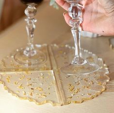 a person is holding a wine glass in front of two other glasses on a table