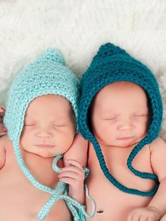 two newborn babies are wearing knitted hats