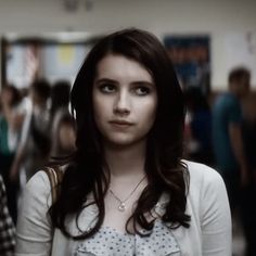 a young woman standing in front of a group of people