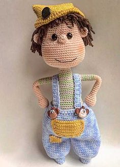 a crocheted doll wearing overalls and a hat with the words free pattern on it