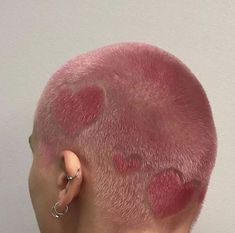 the back of a man's head with pink hair and spots on his forehead