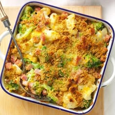 a casserole dish with broccoli, ham and cheese in it next to a fork