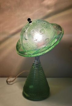 a green glass lamp sitting on top of a table