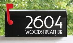 a black mailbox with the word woodstream dr written on it and a red musical note