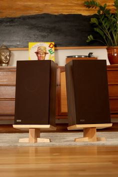 two wooden speakers sitting on top of a hard wood floor