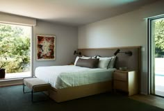 a bedroom with a large bed and sliding glass doors leading to the outside deck area