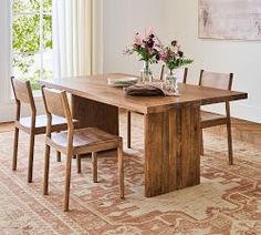 a dining room table with chairs and vases on it