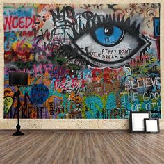 an empty room with graffiti on the wall and a large blue eye painted on the wall