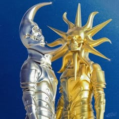 two gold and silver statues are standing next to each other on a blue background with the sky in the background