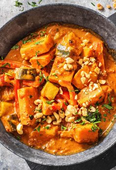 a bowl filled with curry and vegetables on top of a table