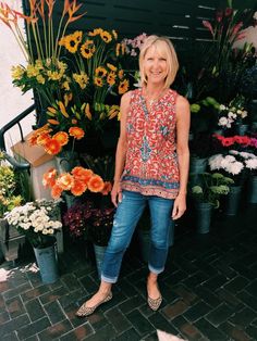 a woman standing in front of some flowers