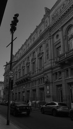 cars are parked on the street in front of an old building