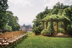 rows of wooden chairs sitting on top of a lush green field