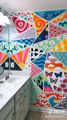 a bathroom decorated with colorful wallpaper and mirrors