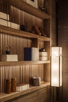 a wooden shelf with books and lamps on it