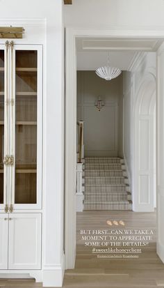 the interior of a house with white walls and wood flooring, built in china cabinets