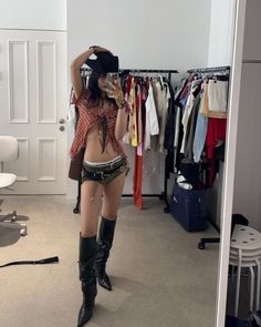 a woman is taking a selfie in front of her mirror while wearing cowboy boots