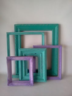 four different colored frames sitting next to each other on a white surface with one purple and one green