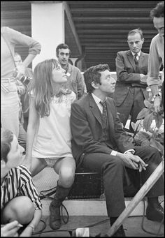 black and white photograph of people sitting on steps with one man holding a baseball bat