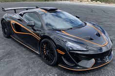 a black and orange sports car parked in a parking lot with no one around it