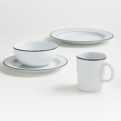 three white cups and saucers with blue rims