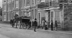 black and white photograph of horse drawn carriage on street