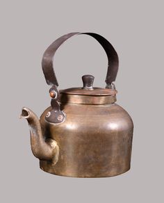 an old tea kettle with a metal handle on it's side and a bird figurine at the top