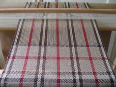 a weaving machine with red and white plaid on it