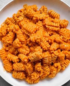 a white bowl filled with macaroni and cheese on top of a gray table