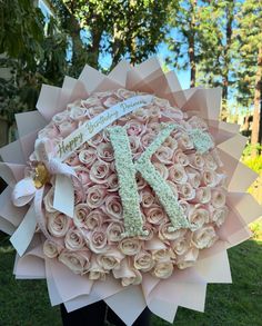 a large bouquet of pink roses with the letter k on it