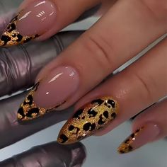 a woman's nails with gold and leopard print on them