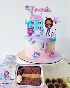 there is a cake and cupcakes on the table with other items around it