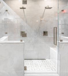 a walk in shower sitting next to a white counter top and tiled floored walls