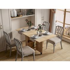 a dining room table with four chairs and plates on the wooden table in front of a window