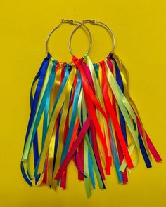 multicolored streamers hang from a metal hoop on a yellow background