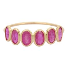 a yellow gold ring with three oval pink stones on the side and four smaller round pink stones