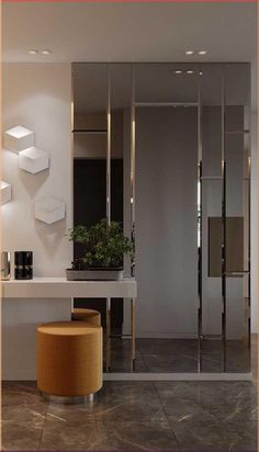 a modern bathroom with a large mirror and stool in the corner, along with a potted plant on the counter