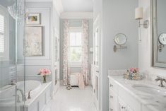 a bathroom with two sinks and a bathtub next to a window in the wall