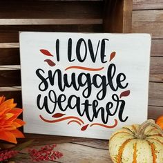 a wooden sign that says i love snuggle weather next to some pumpkins