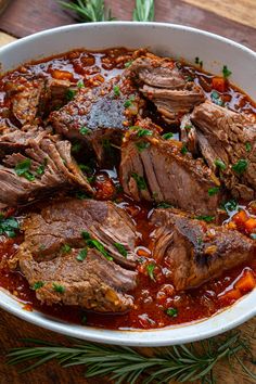 some meat and vegetables are in a white bowl